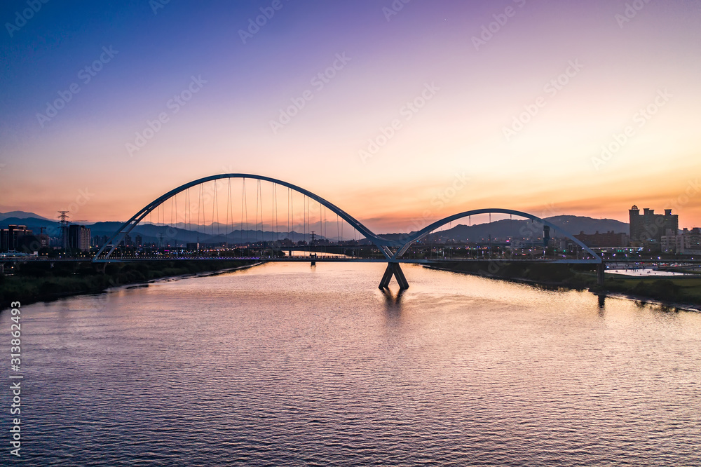 Obraz premium Crescent Bridge - landmark of New Taipei, Taiwan with beautiful illumination at day, aerial photography in New Taipei, Taiwan.