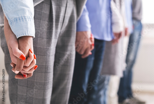 Group of millennials holding hands of each other