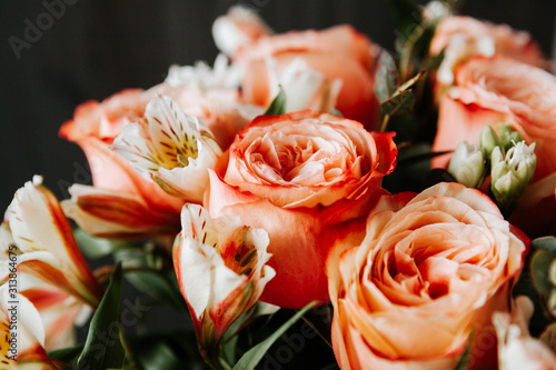  large luxurious bouquet of peony roses of coral color with white freesia in noir style on a dark background. dark romance