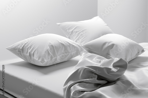 Unmade bed with soft clean white linen and pillows photo