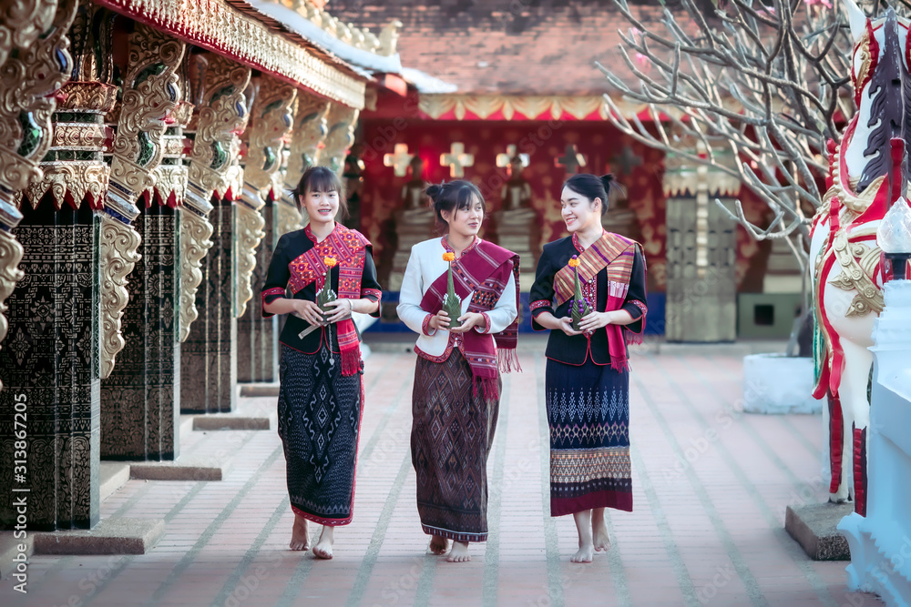 Naklejka premium Three Thai girl In the Phu Thai tribe Standing in the Thai temple area