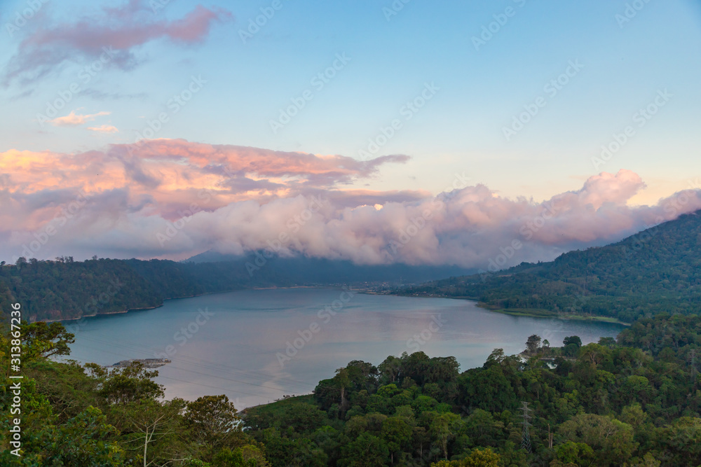 Beautiful sunset over lake Buyan. Scenery nature landscape. Amazing view on volcanic mountains and  cloudy sky. Bali island, Indonesia.
