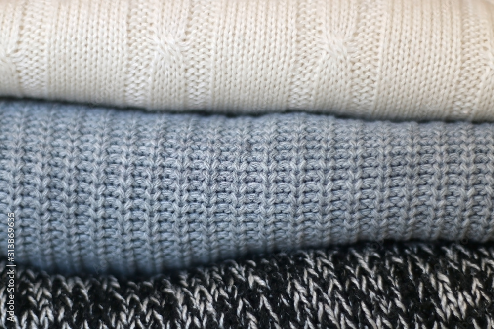 White, gray and black sweaters, close-up. White, gray and black sweaters, close-up.