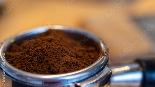 A close shot of the portafilter of coffee machine with a fresh ground coffee.
