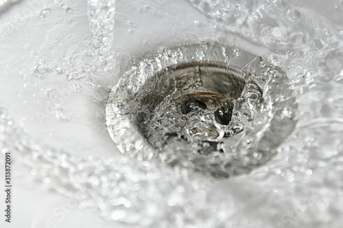 clear water drains into the drain hole of the sink