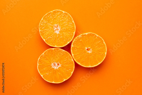 Tangerine on an orange background, fruit flatlay, summer minimal compositon
