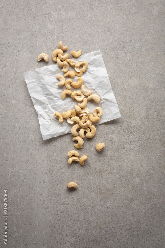Cashew nuts on white paper top view Cashew nuts on white paper top view