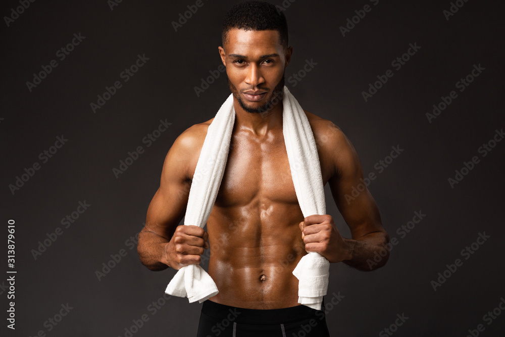 Serious afro man with towel on dark gray background Serious afro man with towel on dark gray background