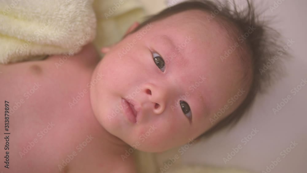 Portrait of baby awake. Newborn baby lies on his back and tries to smile for the first time,Newborn health Portrait of baby awake. Newborn baby lies on his back and tries to smile for the first time,Newborn health