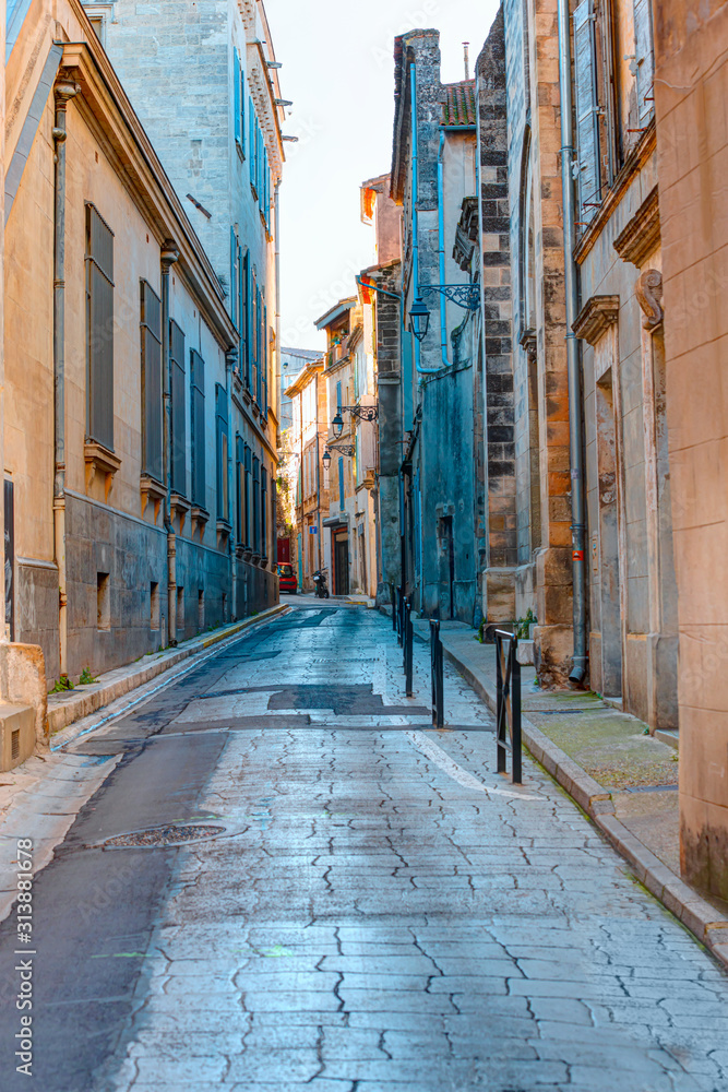 Old traditional typical buildings on the narrow cobblestone streets - Arles, France