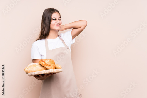 Young caucasian baker woman isolated touching back of head  thinking and making a choice.