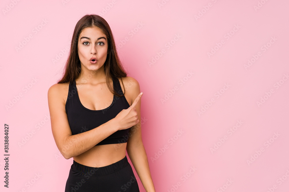 Young caucasian fitness woman doing sport isolated pointing to the side Young caucasian fitness woman doing sport isolated pointing to the side