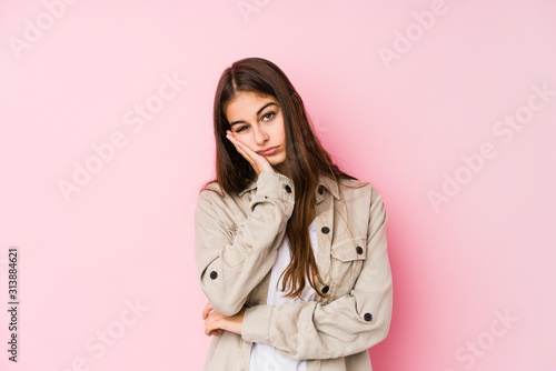 Young caucasian woman posing in a pink background who is bored, fatigued and need a relax day. © Asier