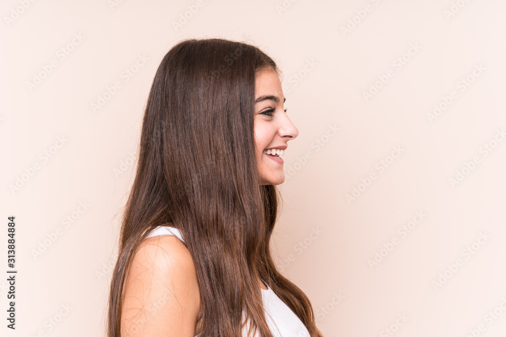 Young cute caucasian woman against a beige background Young cute caucasian woman against a beige background