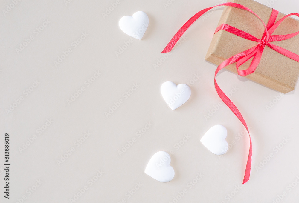 Gift box and white heart on a beige background. Valentine's day and romantic concept. Flat lay. Copy space. Gift box and white heart on a beige background. Valentine's day and romantic concept. Flat lay. Copy space.