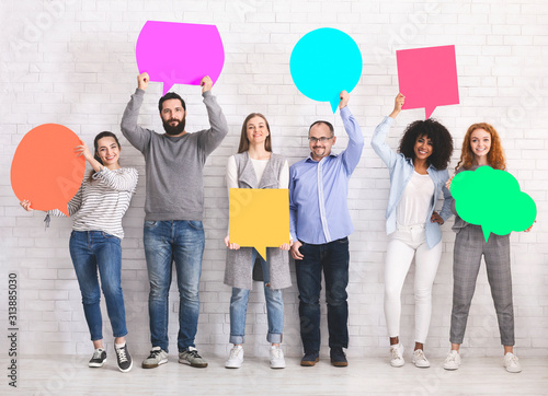 Group of diverse friends holding blank colorful speech bubbles