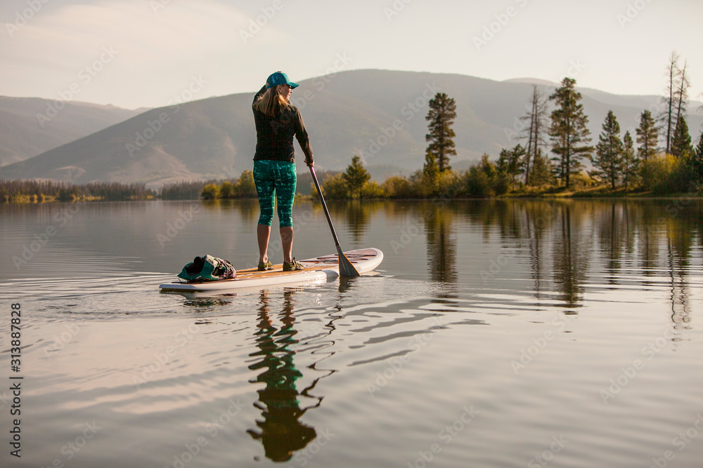 A female paddlboarder on Lake Dillon in Summit County, Colorado in the early morning. A female paddlboarder on Lake Dillon in Summit County, Colorado in the early morning.