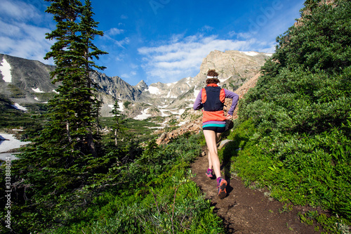      Two women trail running to the high alpine lake. Lake Isabel is part of Brainard Lake Recreation Area outside of Nederland, Colorado. One woman trail running to the high alpine lake. Lake Isabel is part of Brainard Lake Recreation Area outside of Nederland, Colorado. photo