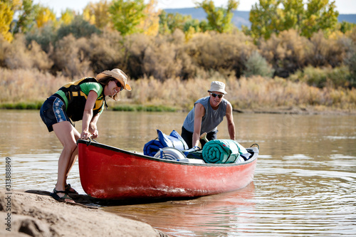 One man and one woman push off their canoe wile canoeing Rudy Horsetheif Canyon near Fruita, Colorado. photo