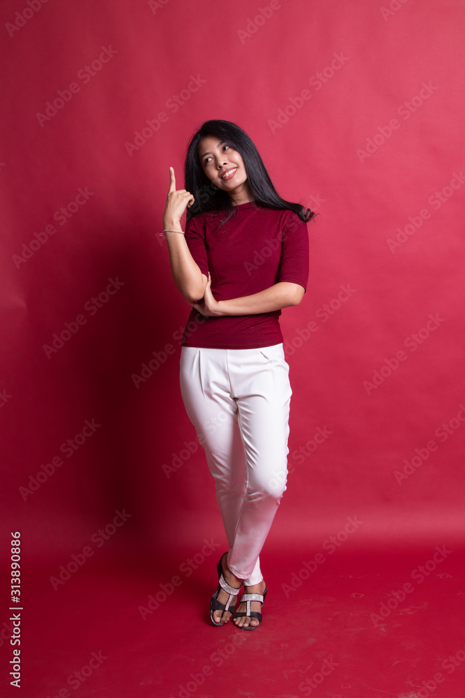 Full body of beautiful young asian woman pointing up.