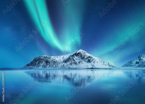 Aurora Borealis, Lofoten islands, Norway. Northen lights, mountains and reflection on the water. Winter landscape during polar lights. Norway travel - image