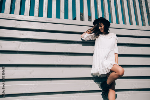 lifestyle portrait of young stylish hipster woman, wearing trendy white dress © Mykola