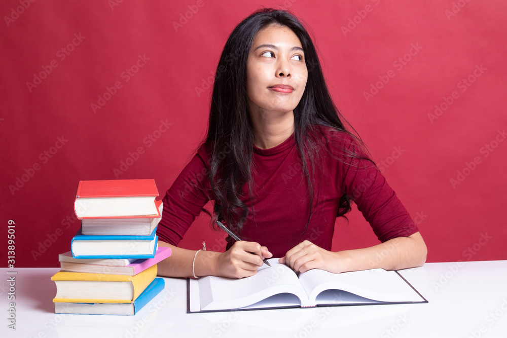 Young Asian woman read a book with books on table. Young Asian woman read a book with books on table.