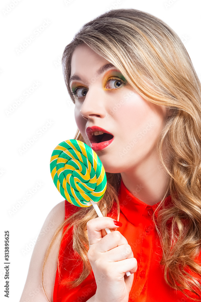Portrait of Surprised Caucasian Blond Girl With Round Lollipop. Posing in Red Shirt in Studio Against White.