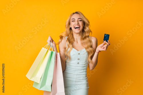Seasonal sales. Excited woman holding credit card and bags