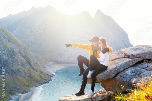 Happy couple of love are hiking on top of Mountain in Lofoten island, Norway photo