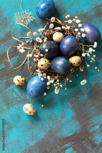 Classic blue 2020. Blue easter eggs in a nest on a blue stone or slate background. Top view flat lay background. Copy space.
