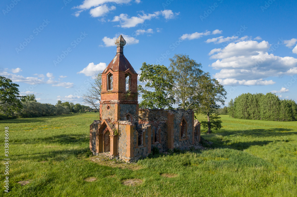 Orthodox Church and nature. Green garden and architecture. Under the blue sky a house which is surrounded by a beautiful natural environment. Trees, bushes and building - Estonia, Europe.