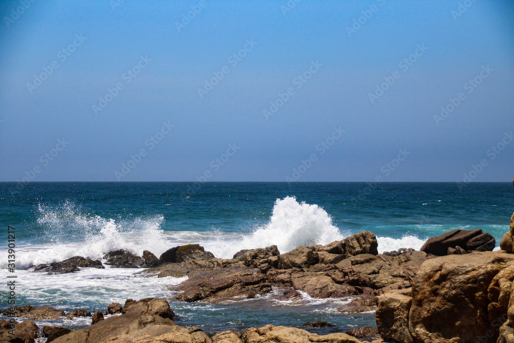 Beautiful blue oceans with waves breaking on the rocks