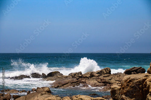 Beautiful blue oceans with waves breaking on the rocks