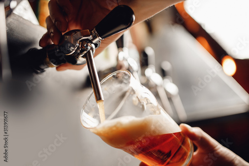 Schilderij op canvas Light Draft cold beer pour in glass from crane in pub