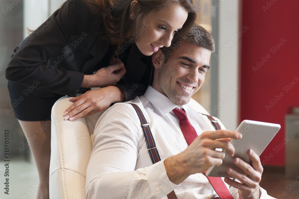 © MDBPIXS - Businesswoman looking over male colleagues shoulder pointing at digital tablet © MDBPIXS - Businesswoman looking over male colleagues shoulder pointing at digital tablet