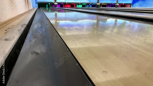 bowling ball rolls and knocks down pins