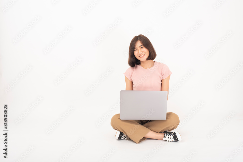 Cute Asian teen woman is working with computer on white background Cute Asian teen woman is working with computer on white background