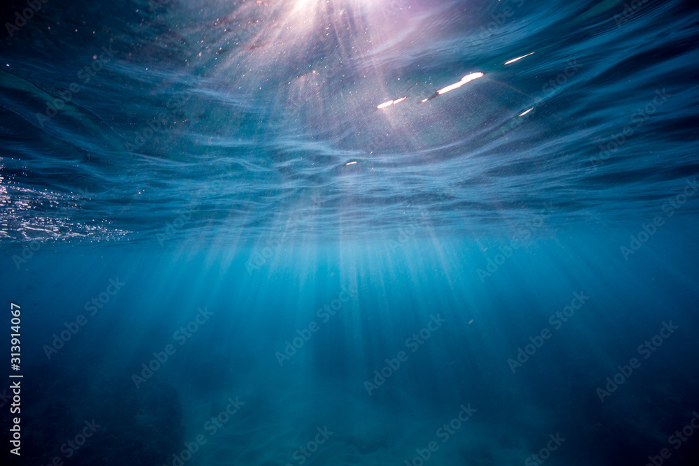 Sunrise piercing through clear blue waters in Oahu, Hawaii Sunrise piercing through clear blue waters in Oahu, Hawaii