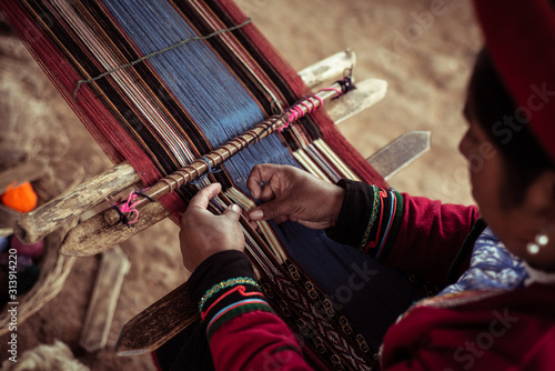 High angle view of woman weaving alpaca wool on loom photo