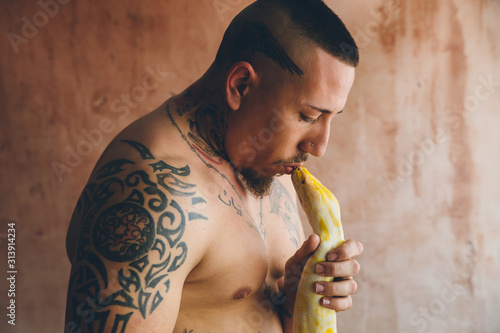 Close up of man kissing python snake photo