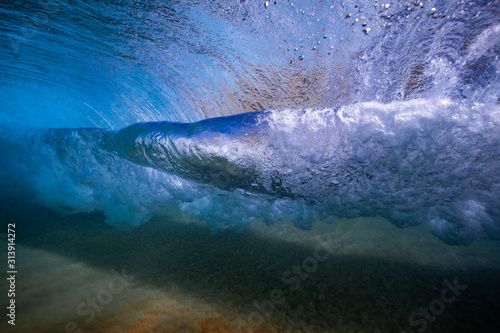 Crystal clear wave twist shot from below the surface in Maui, Hawaii