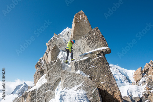 Alpinist rappels a short rock step on the Cosmiques Ridge photo