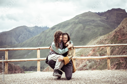 lesbian couple laugh and hold each other in travel selfie photo