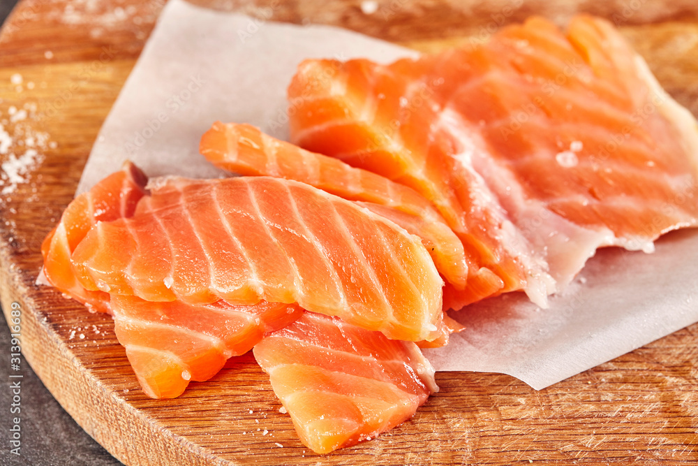 Raw red salmon fillets on wooden board. Close up. Raw red salmon fillets on wooden board. Close up.