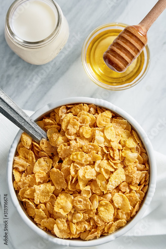 Bowl full of cereals with honey and milk. Top view