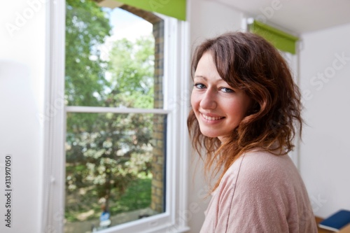 Young woman in trendy office looking at camera and smiling