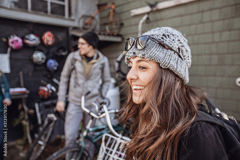 A young woman smiles while looking at bikes to rent in Maine A young woman smiles while looking at bikes to rent in Maine