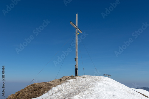 Top and Summit Cross of Jochberg, 1565 m in Winter. Located in Bavarian Prealps near Kochel am See, Upper Bavaria, Germany