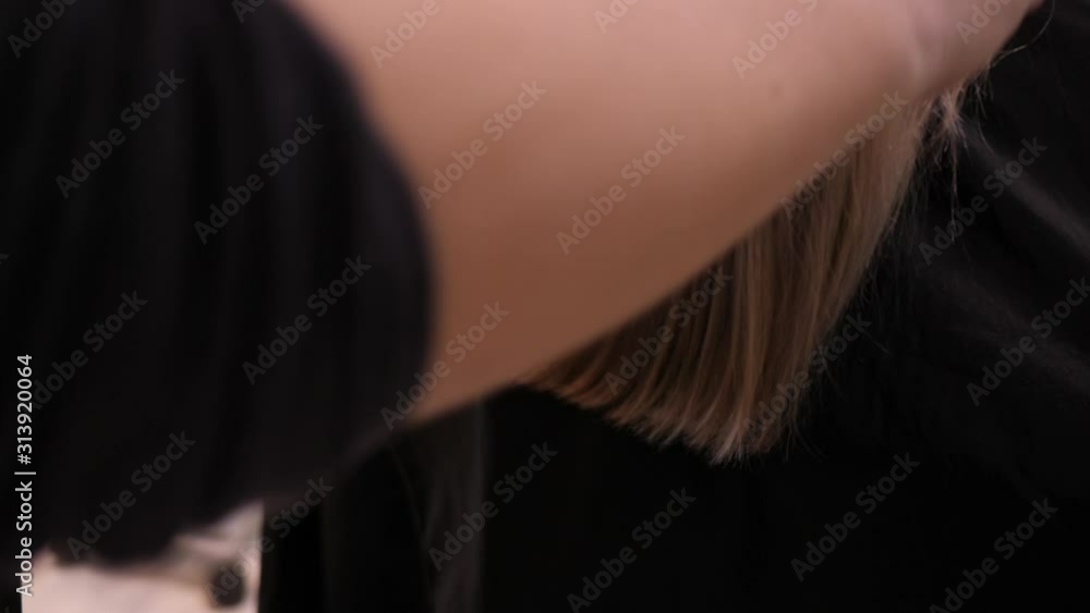Hairstyle beauty salon stylist combing beautiful healthy shine hair after treatment a woman client Hairstyle beauty salon stylist combing beautiful healthy shine hair after treatment a woman client